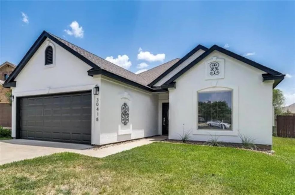 Single story home with stucco siding, an attached garage, and concrete driveway