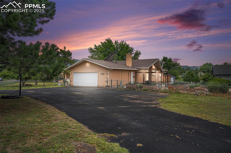 Ranch-style house featuring driveway, an attached garage, a chimney, and stucco siding