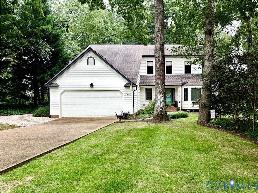 View of front of house featuring concrete driveway, a shingled roof, a front yard, and an attached garage
