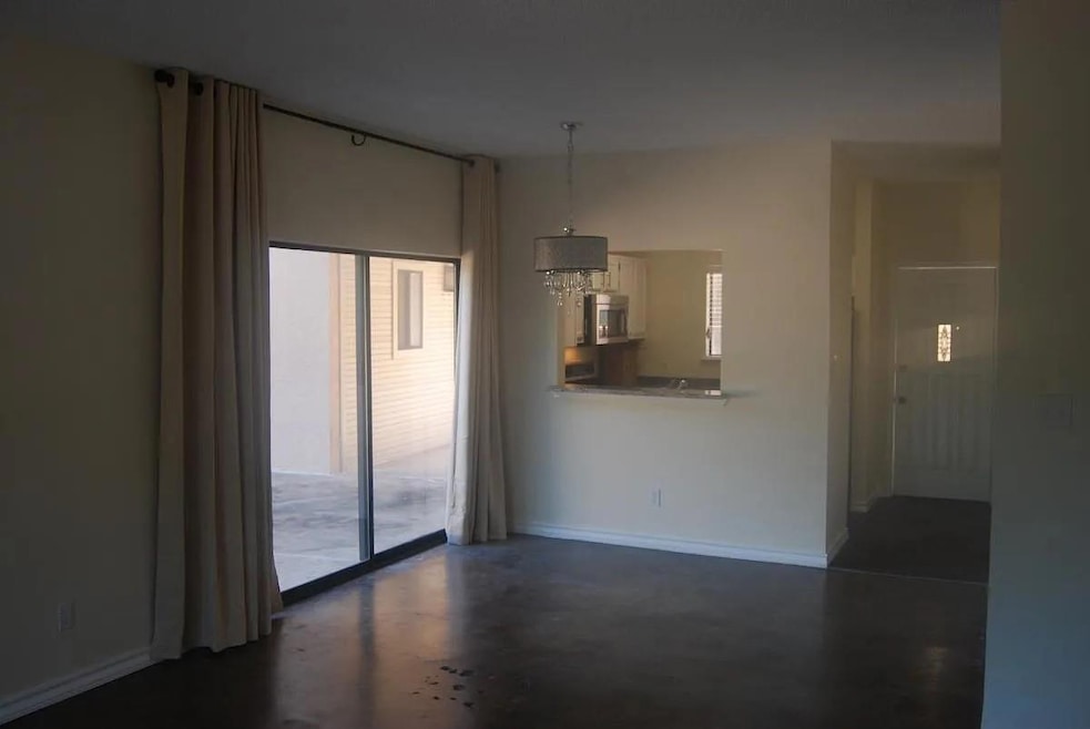 Unfurnished room featuring concrete flooring and baseboards