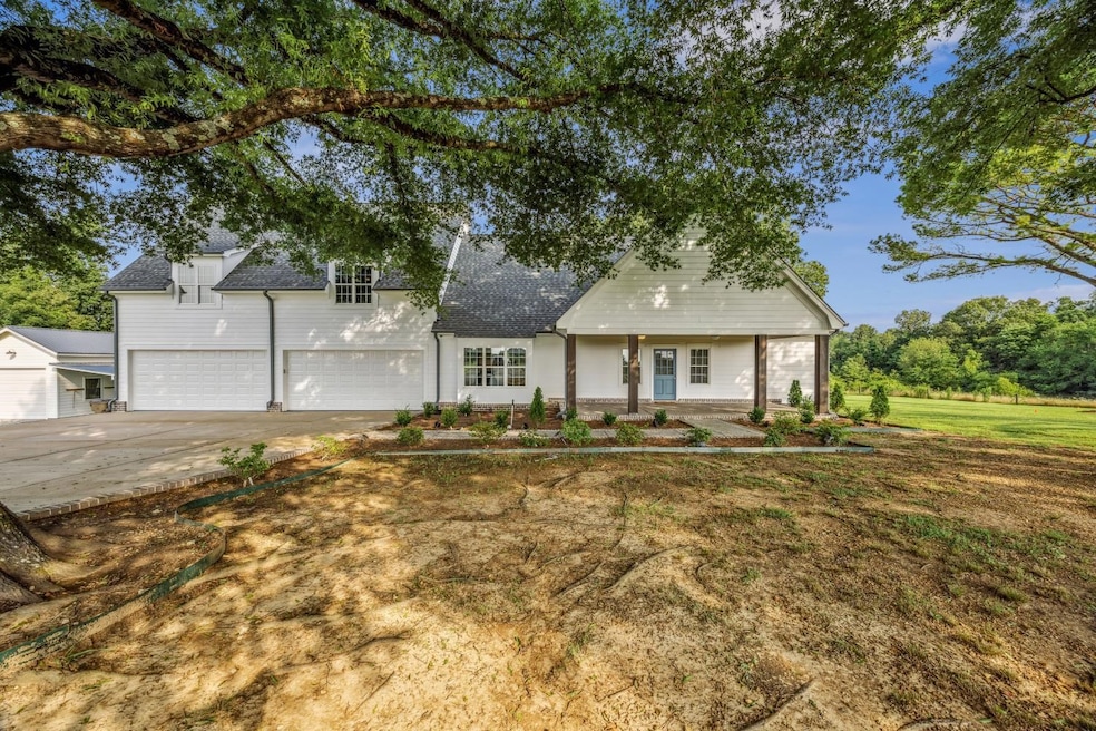 View of front of home featuring a garage, driveway, and a shingled roof