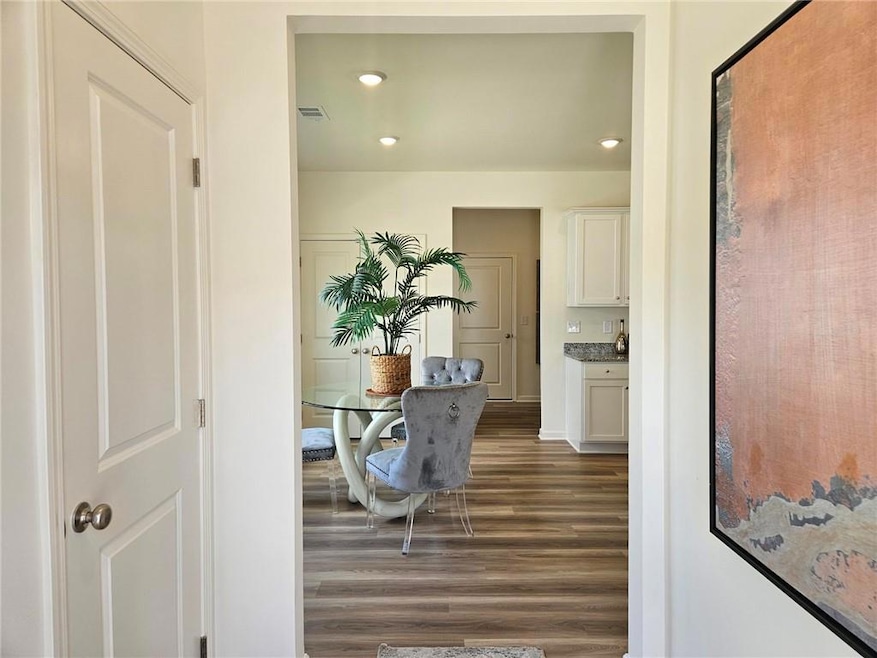 Hallway with dark wood finished floors and recessed lighting