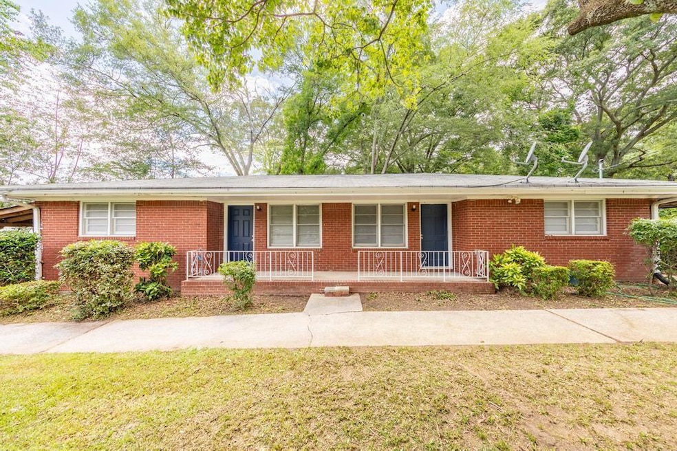 Single story home featuring covered porch, brick siding, and a front lawn