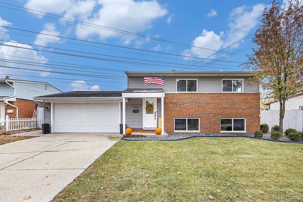 Bi-level home with brick & vinyl siding, and attached garage