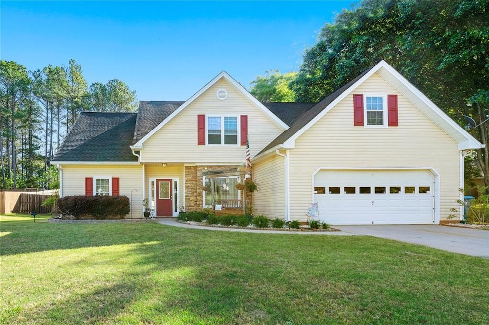 Traditional home featuring roof with shingles, sto