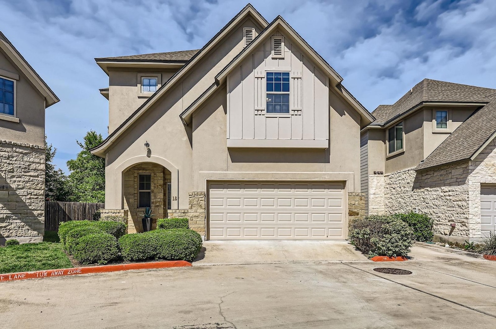 View of front of home with stone siding, driveway
