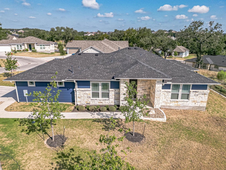 Single story home with a residential view, stone siding, and roof with shingles