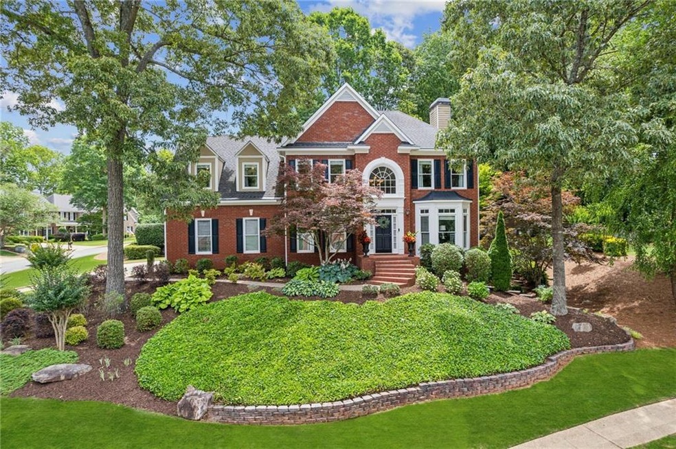 Colonial inspired home with brick siding, a front yard, and a chimney