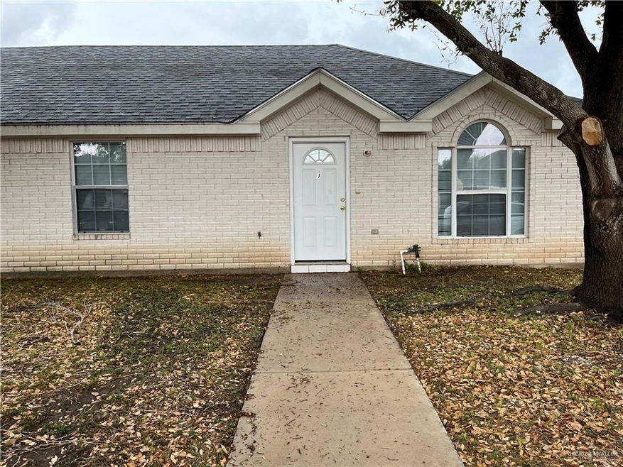 Entrance to property featuring brick siding and roof with shingles