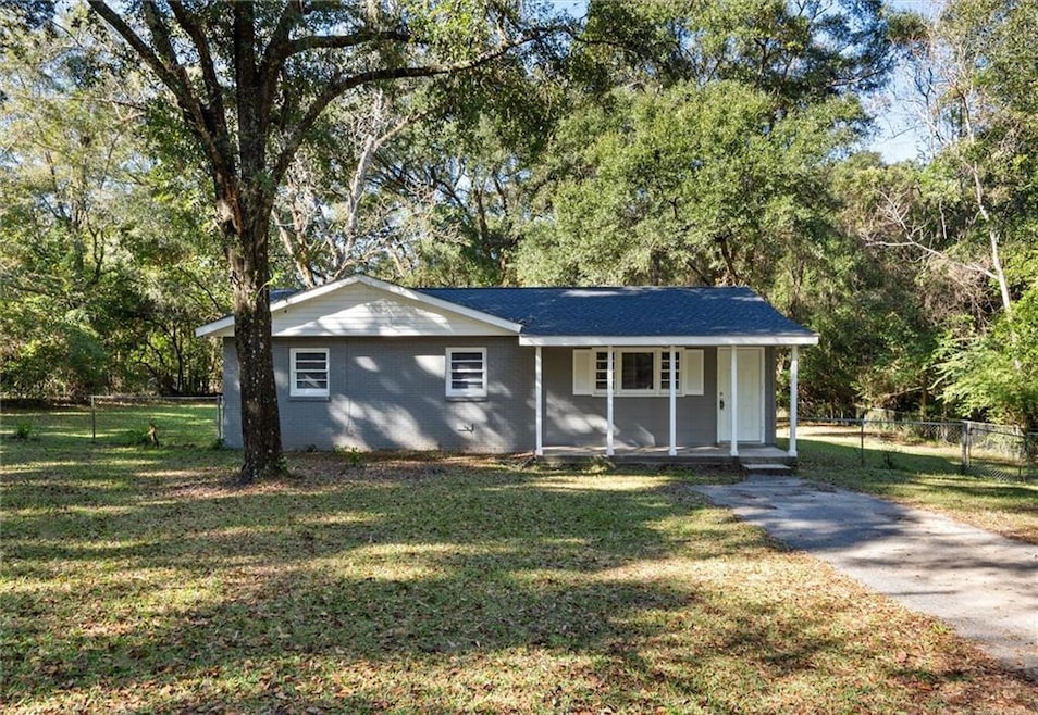 Single story home with a porch and a front lawn