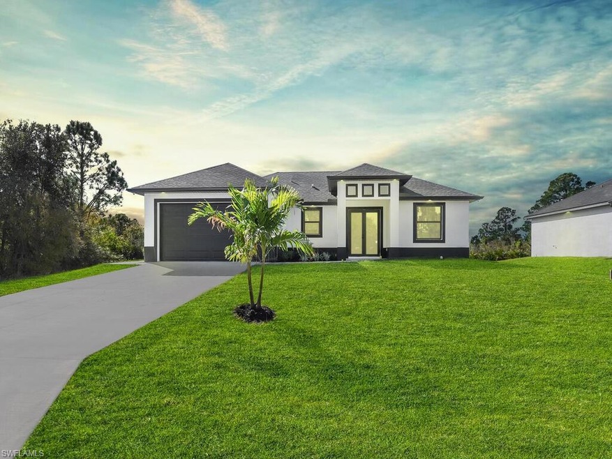 View of front facade featuring a garage and a lawn