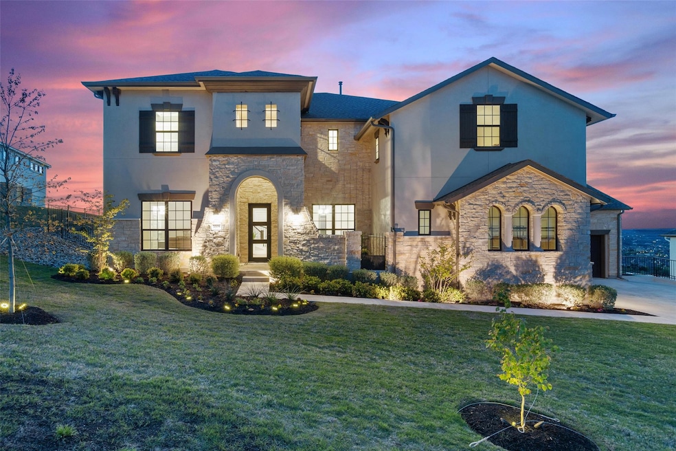 View of front of house with stone siding, a yard,