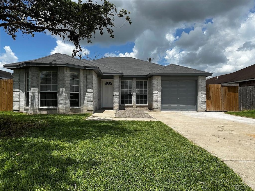 Single story home featuring driveway, a garage, a shingled roof, and brick siding