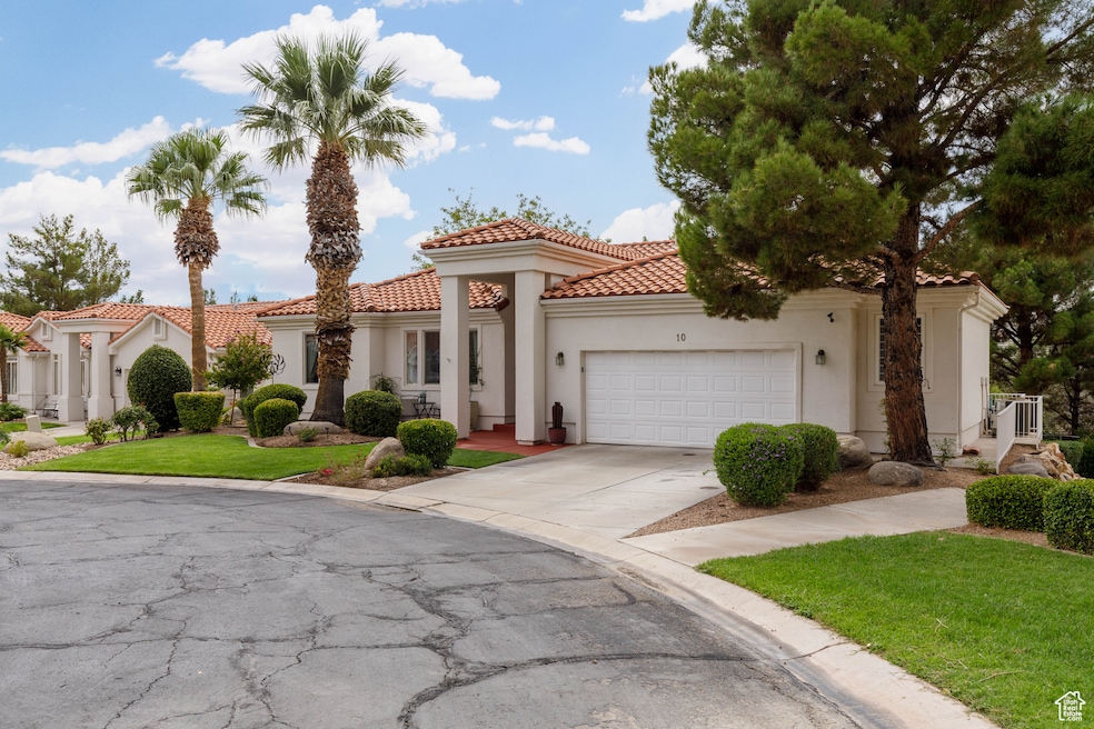Mediterranean / spanish home featuring concrete driveway, a front lawn, an attached garage, stucco siding, and a tile roof
