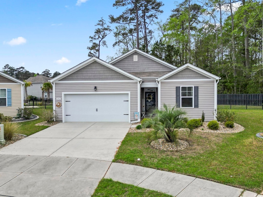 Ranch-style home with concrete driveway, a front lawn, fence, and an attached garage