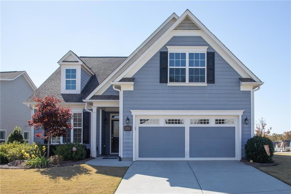 View of front of property featuring roof with shingles, a garage, driveway, and a front lawn