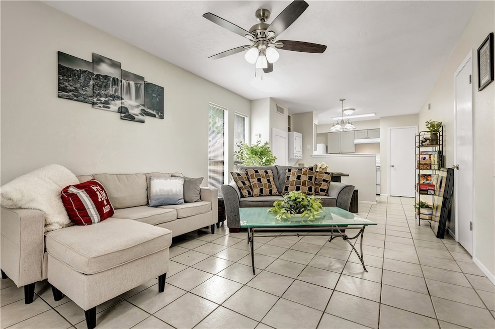 Living room with ceiling fan with notable chandeli