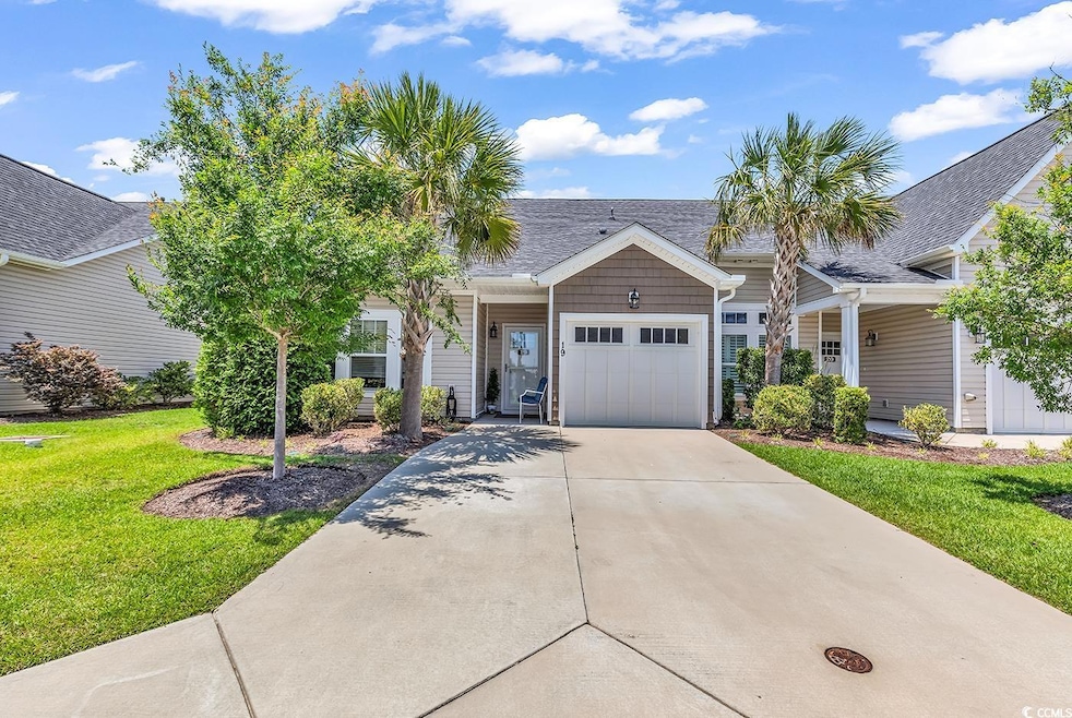 View of front of house featuring a garage, driveway, a front lawn, and a shingled roof