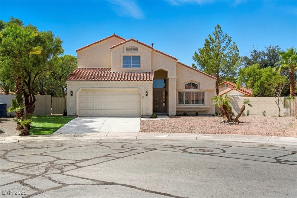 Mediterranean / spanish house with driveway, stucco siding, a tiled roof, and a gate