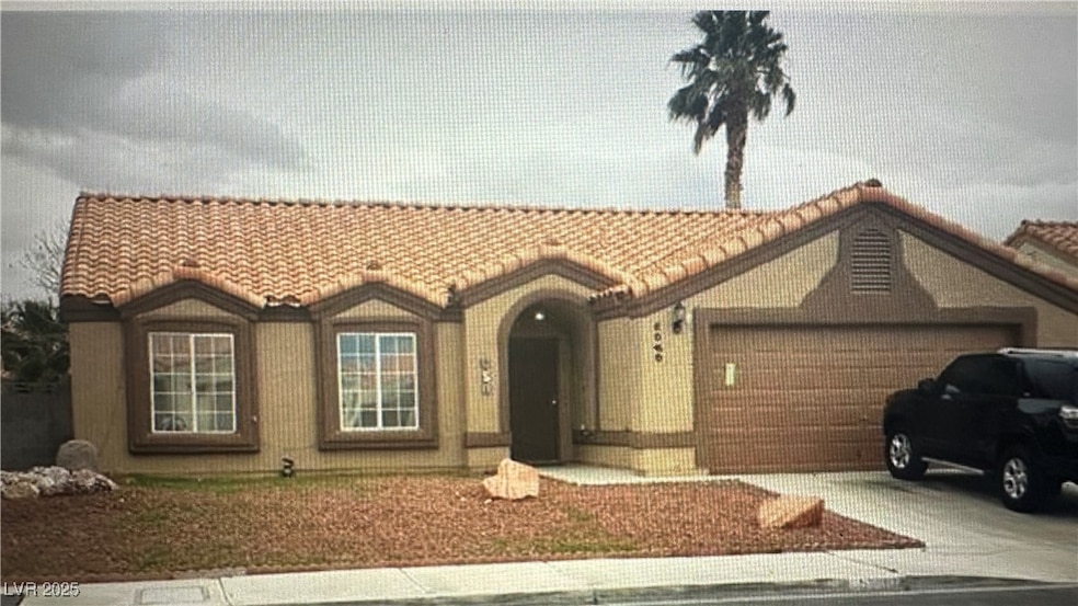 View of front of house featuring a tiled roof, a g
