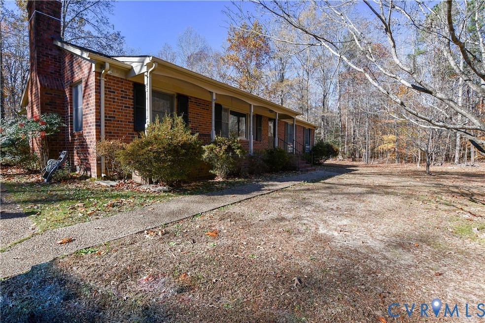 View of side of home with brick siding, covered porch, and a chimney