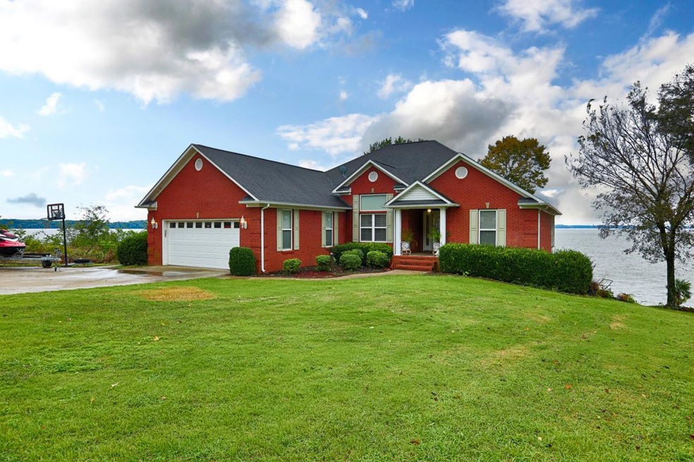 Front View of home with unbelievable views of the Tn River from the front yard to the back patio and covered balcony/deck to the spacious dock. 