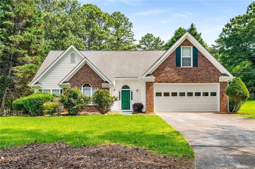Traditional-style house featuring brick siding, concrete driveway, a front lawn, and a shingled roof