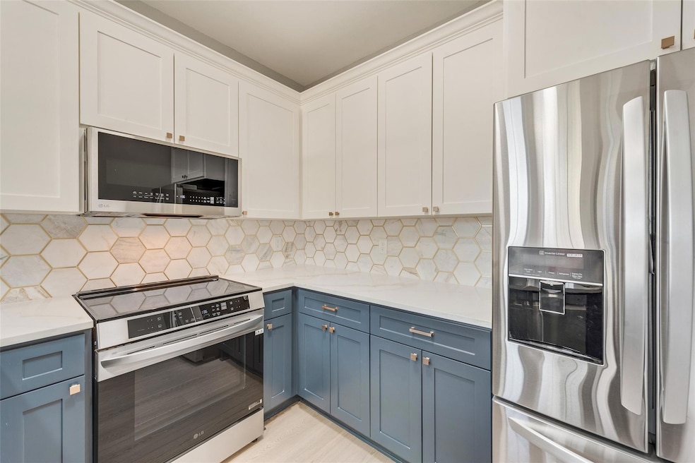 Beautiful custom backsplash and blue lower cabinet