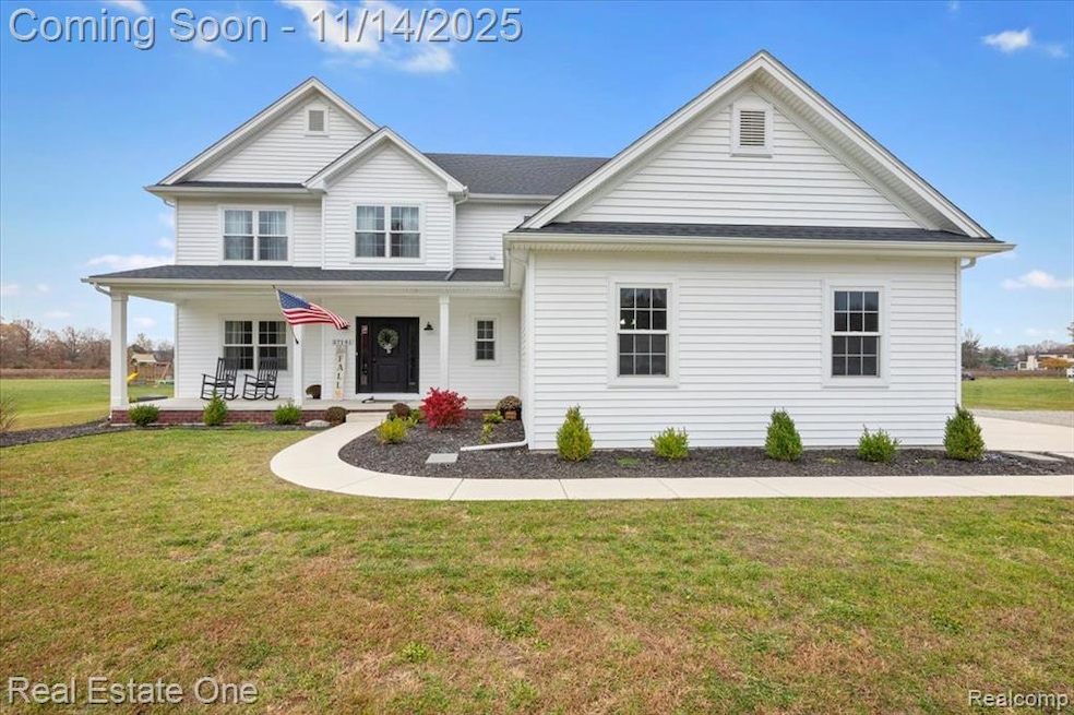 View of front of home featuring covered porch, a front yard, and roof with shingles
