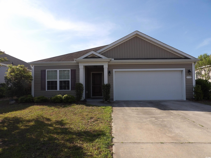View of front of home featuring concrete driveway, a garage, and a front lawn