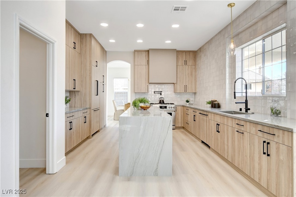 Kitchen featuring light brown cabinets, a sink, hi