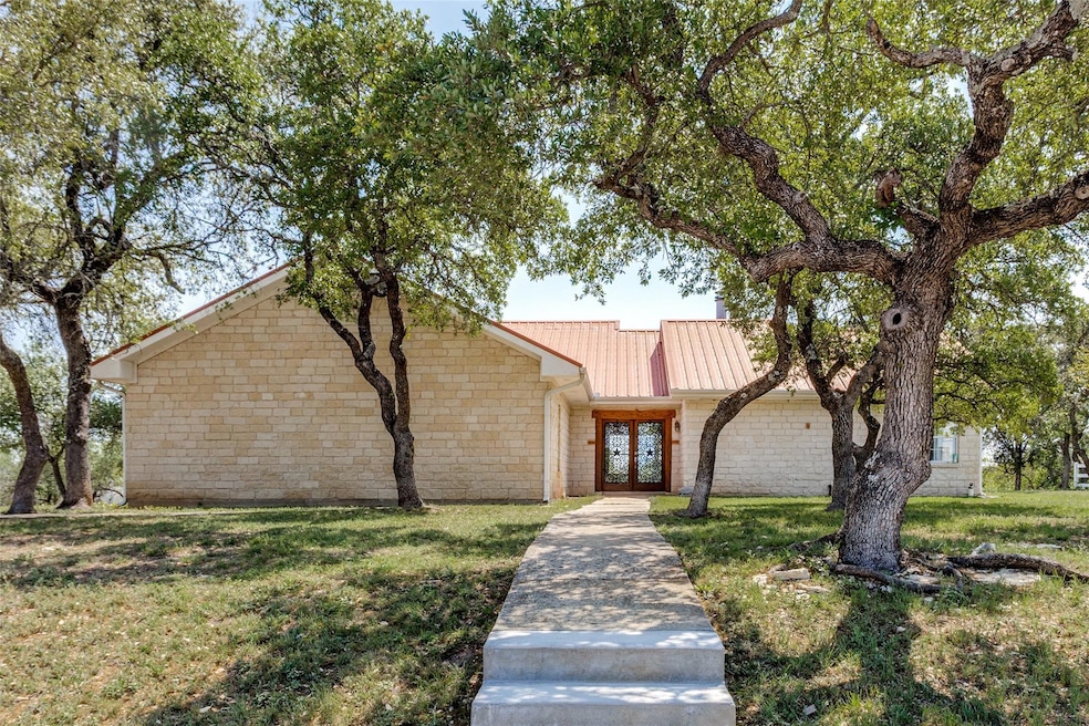 Mid-century home with a front lawn, stone siding,