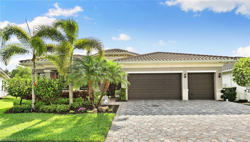 Mediterranean / spanish home featuring a garage, decorative driveway, a tile roof, and a front lawn