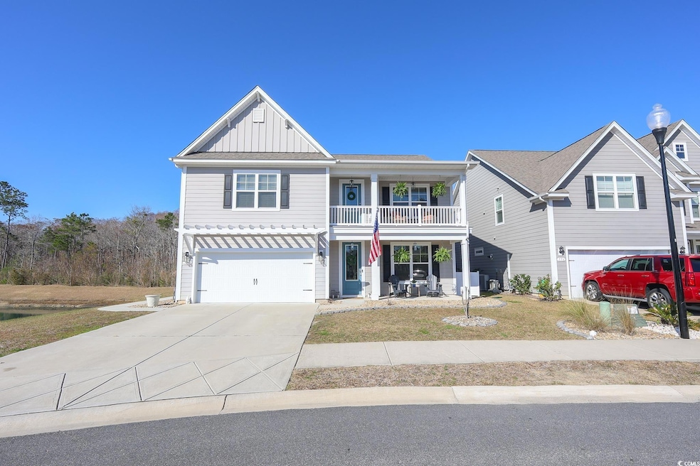 View of front of property with board and batten siding, covered porch, a balcony, a garage, and driveway