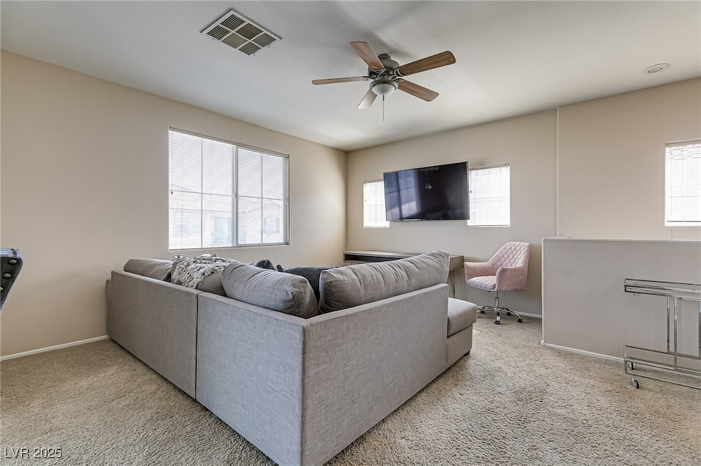 Living area featuring a ceiling fan, carpet floors