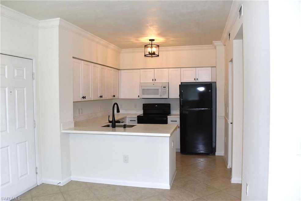 Kitchen featuring a sink, black appliances, light 