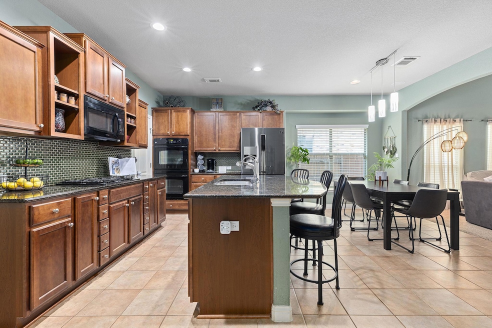 Kitchen featuring a breakfast bar area, backsplas