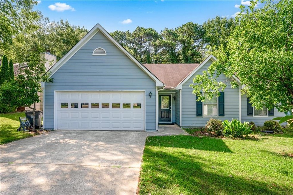 View of front of property featuring a garage and a front yard