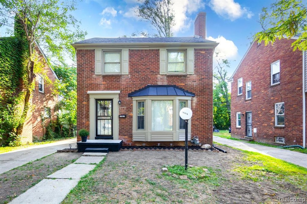 Colonial home with a chimney and brick siding