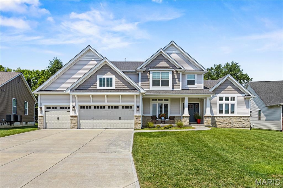 Craftsman house featuring stone siding, covered porch, concrete driveway, a front yard, and a sh