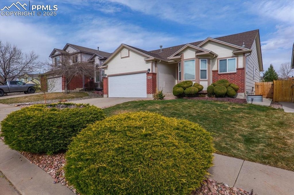 Ranch-style home with concrete driveway, a gate, an attached garage, brick siding, and fence