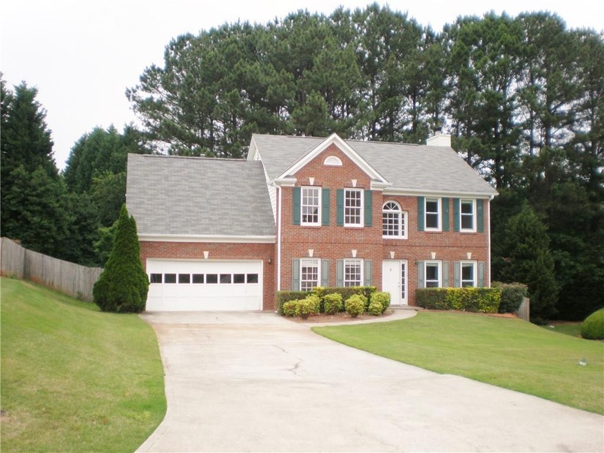 Colonial home featuring a garage and a front yard