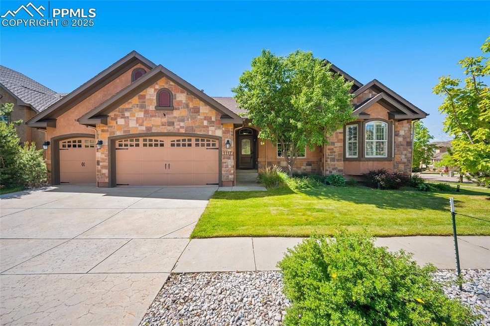 View of front facade featuring an attached garage, concrete driveway, a front lawn, and stone siding