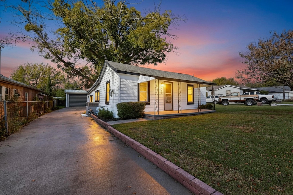 Bungalow featuring a porch, an outdoor structure, and driveway