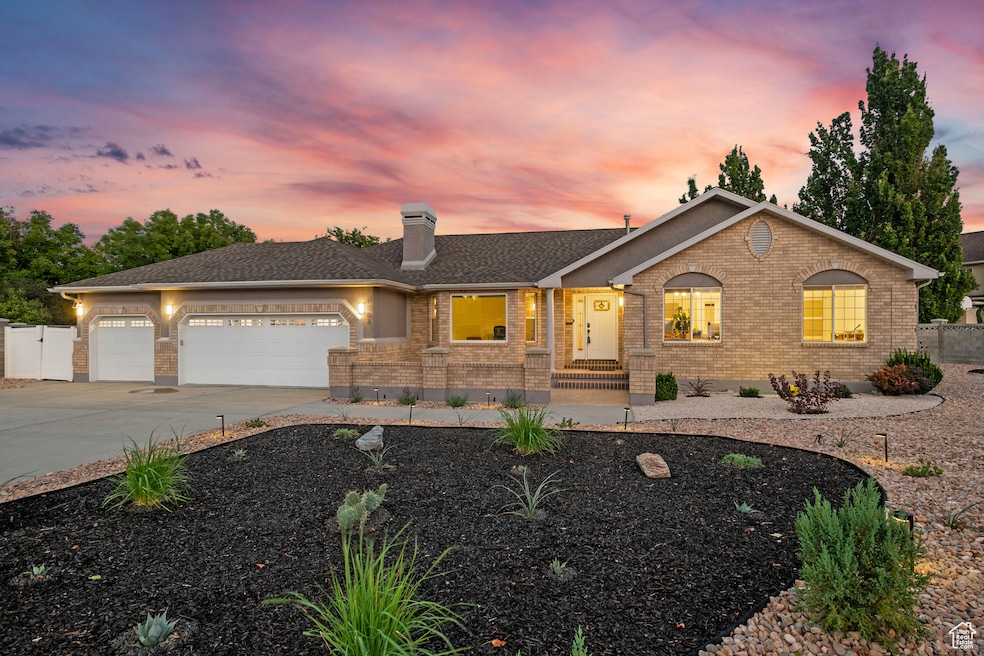 Ranch-style home with brick siding, concrete driveway, an attached garage, and a chimney