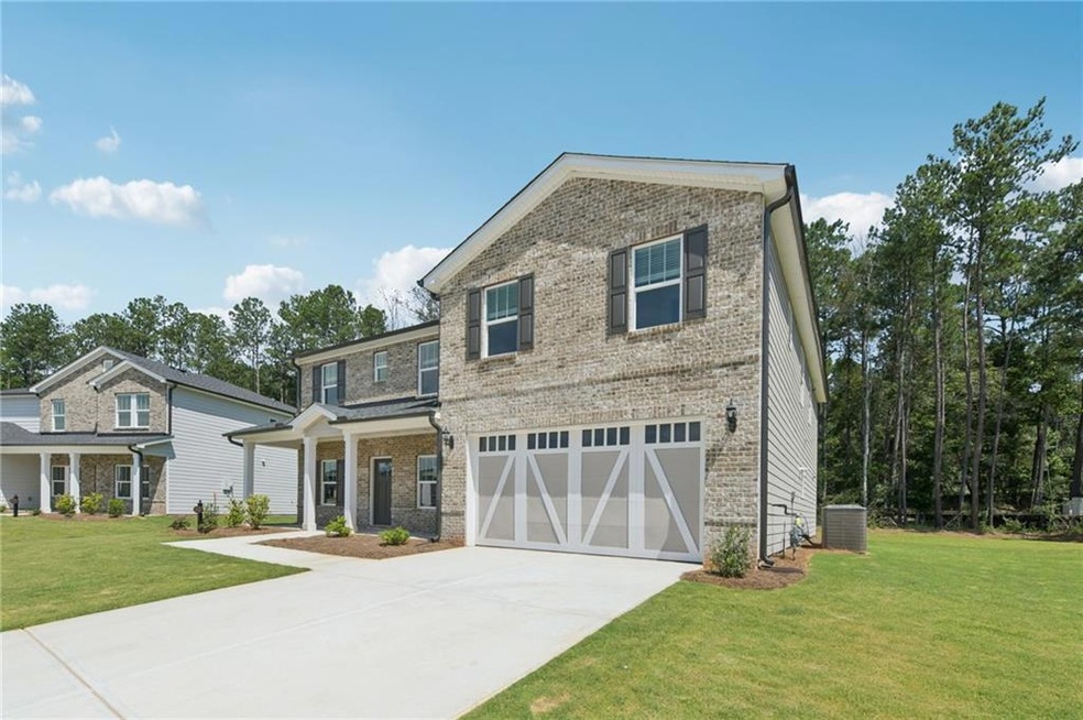View of front of property with driveway, brick siding, a front lawn, and an attached garage