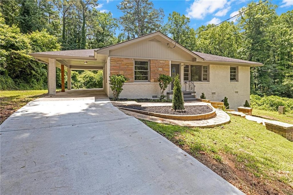Ranch-style home featuring concrete driveway, a front yard, an attached carport, and brick siding