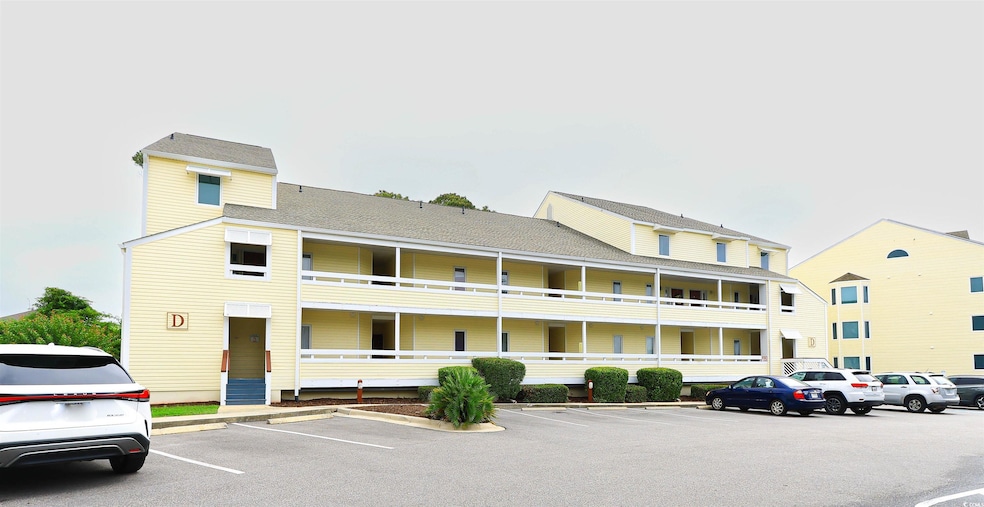 View of building exterior featuring uncovered parking