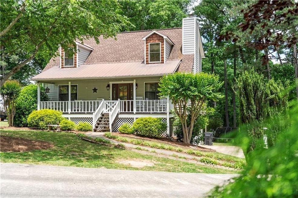 Cape cod-style house with a porch, a chimney, and a shingled roof