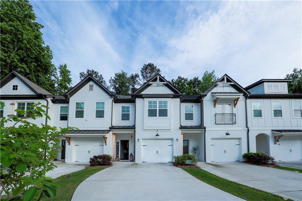 Multi unit property with an attached garage, driveway, a standing seam roof, and metal roof